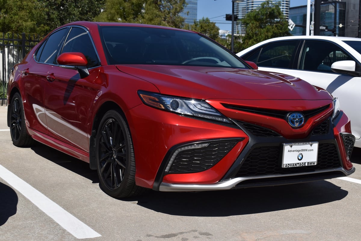 A red Toyota Camry SE luxury sedan in the city