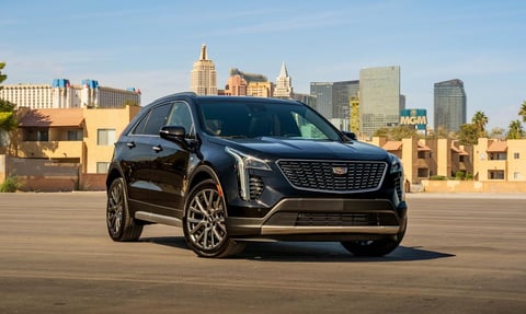Black Cadillac XT4 SUV parked on rooftop with Manhattan skyline in background