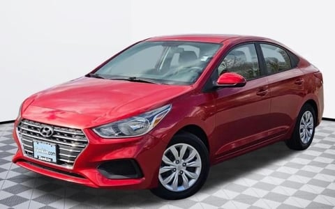 Red Hyundai sedan parked on a checkered floor against a white background